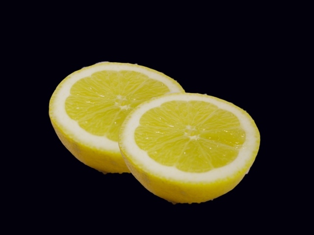 Две половинки лимона на черном фоне