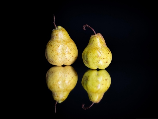 Две груши отражаются в зеркальной поверхности 