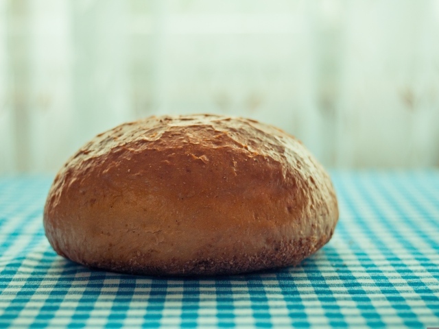 Круглая буханка хлеба лежит на столе