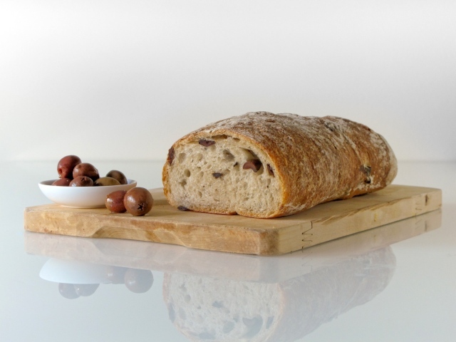 Свежий хлеб с оливками на разделочной доске