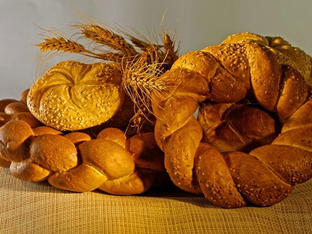 Колоски свежего хлеба на столе с пшеницей