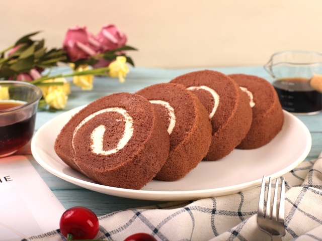 Шоколадный бисквитный рулет с кремом на тарелке