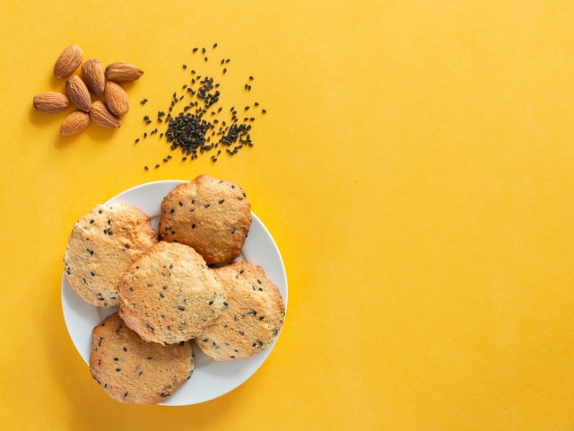 Печенье на желтом фоне с кунжутом и миндальным орехом