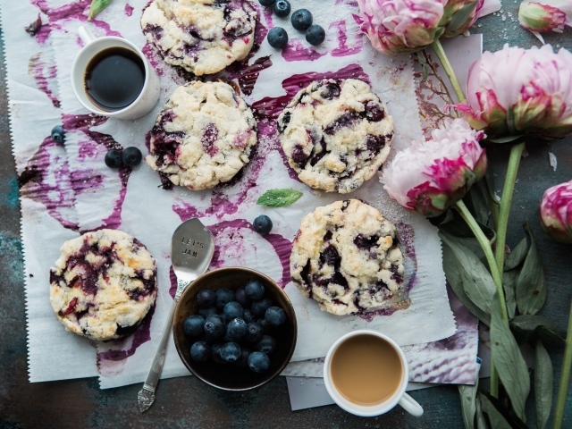 Печенье с ягодами черники на столе с цветами и кофе