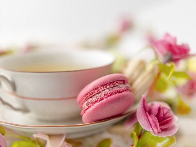 Чашка чая с десертом макарун и цветами розы
