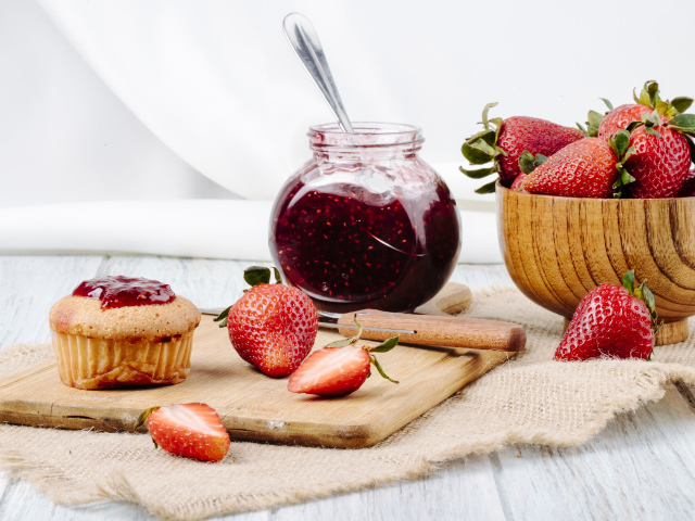 Кекс со свежей клубникой и джемом на столе