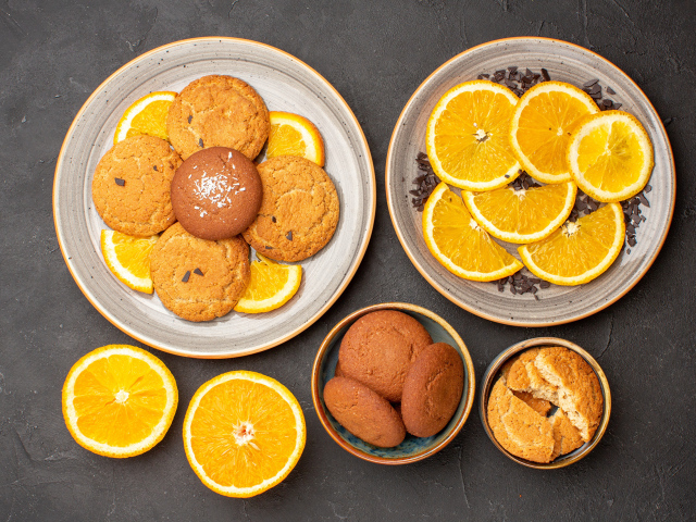 Вкусное печенье на тарелке с апельсинами