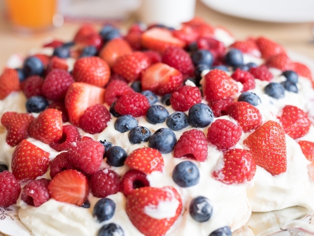 Десерт с кремом и свежими ягодами малины, клубники и черники