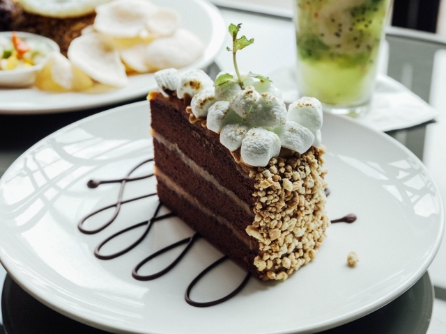 Кусок шоколадного торта с маршмеллоу на белой  тарелке