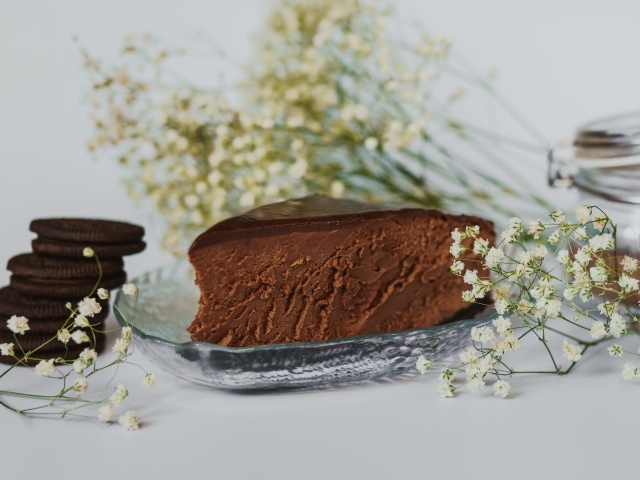 Кусок шоколадного пирога с белыми цветами гипсофилы