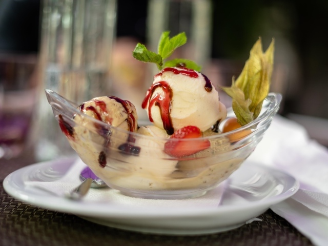 Шарики фруктового мороженого в стеклянной пиале на столе