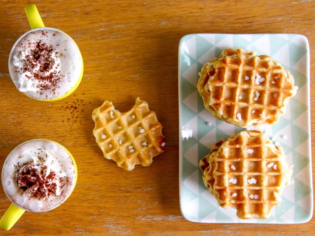 Сладкие вафли на столе с капучино