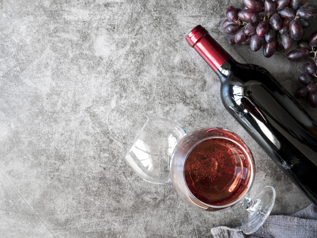 Бутылка красного вина с бокалами на столе