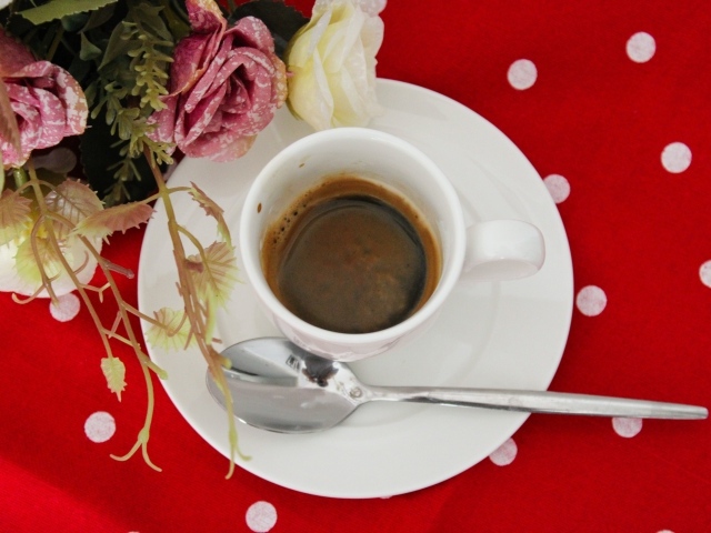 Чашка кофе на столе с цветами розы