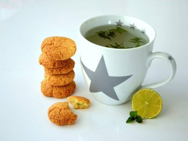 Чашка чая на столе с лимоном и печеньем