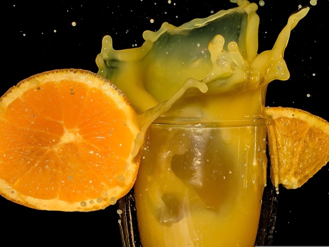 Свежий апельсиновый сок на черном фоне