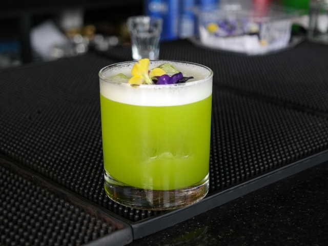 Зеленый коктейль в стакане с цветами