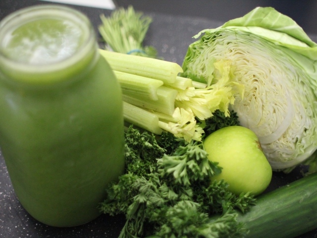 Полезное зеленое смузи на столе с овощами  и зеленью 