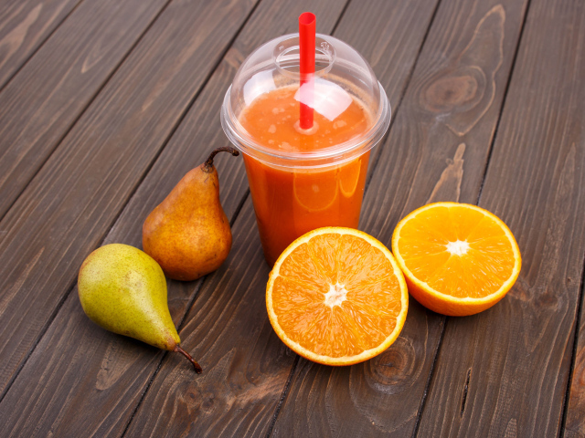 Сок на столе с грушами и апельсином