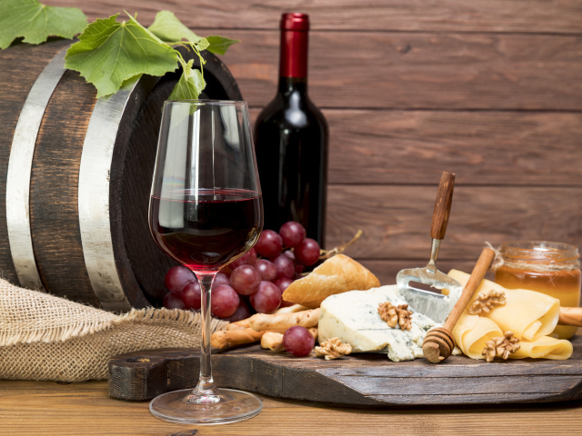 Красное вино с сыром и орехами на столе