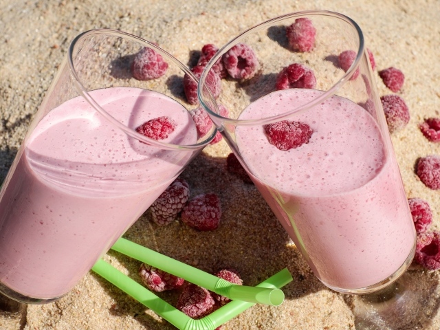 Два стакана ягодного смузи с малиной на песке 
