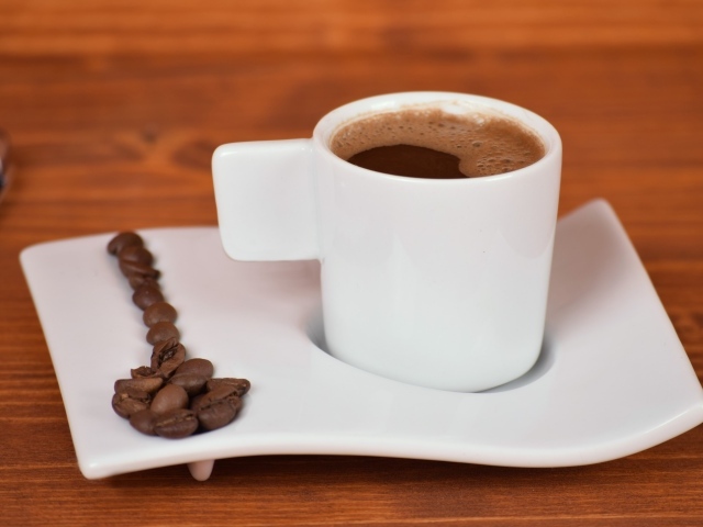 Белая чашка горячего кофе на столе 