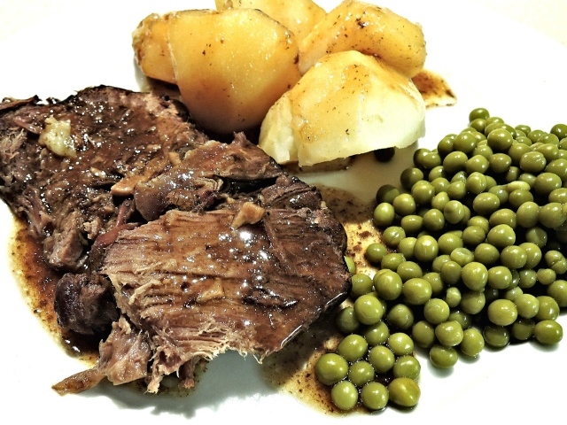 Кусок мяса с картофелем и зеленым горошком