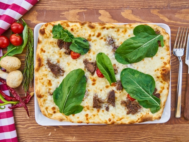 Мясная пицца с сыром и зелеными листьями