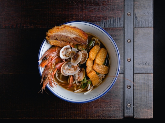 Суп с лапшой и морепродуктами на деревянном столе
