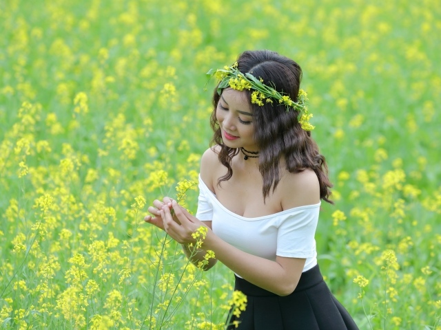 Девушка азиатка на рапсовом поле