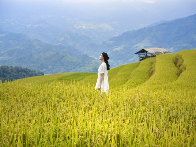Девушка азиатка в белом платье дышит горным воздухом