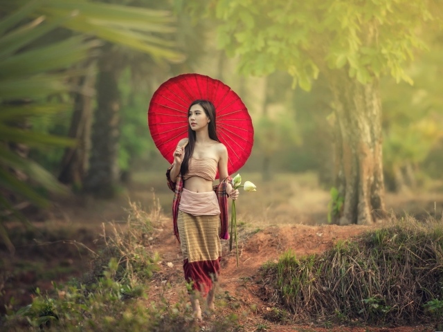 Девушка азиатка с красным зонтом и цветами лотоса