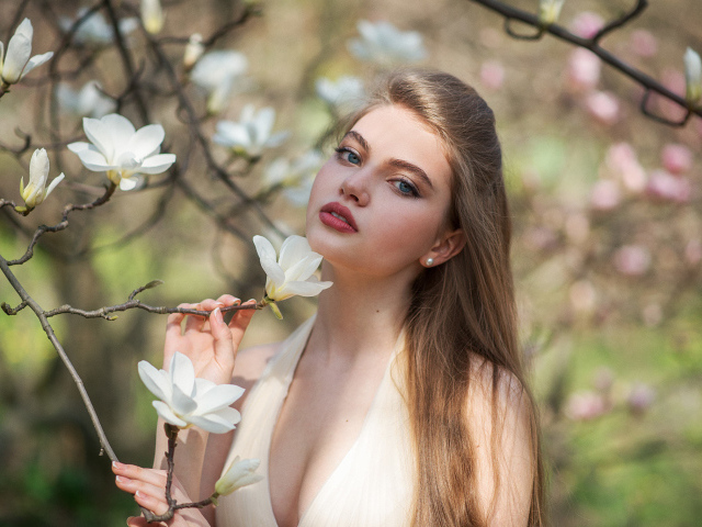 Красивая девушка с белыми цветами магнолии
