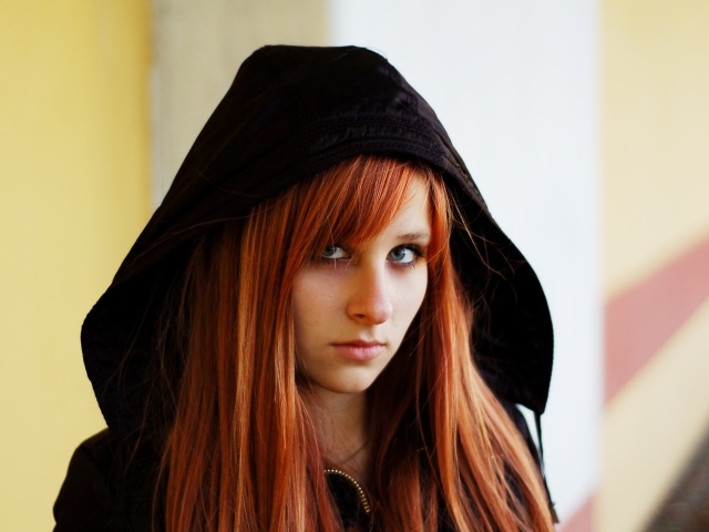 Красивая рыжеволосая девушка в черном балахоне