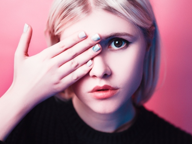 Кареглазая девушка закрыла глаз рукой