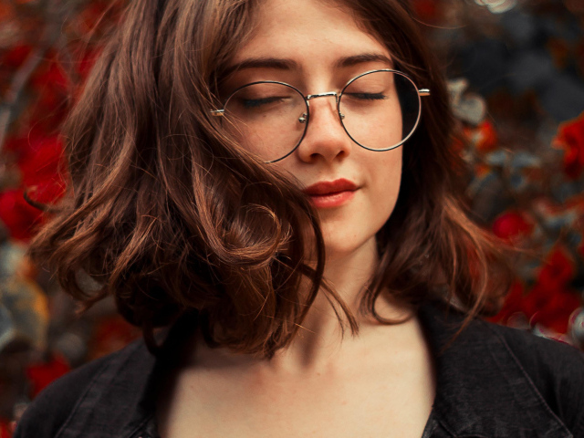 Мечтательная девушка в очках с закрытыми глазами