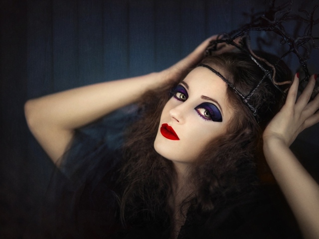 Девушка в черном наряде с ярким макияжем
