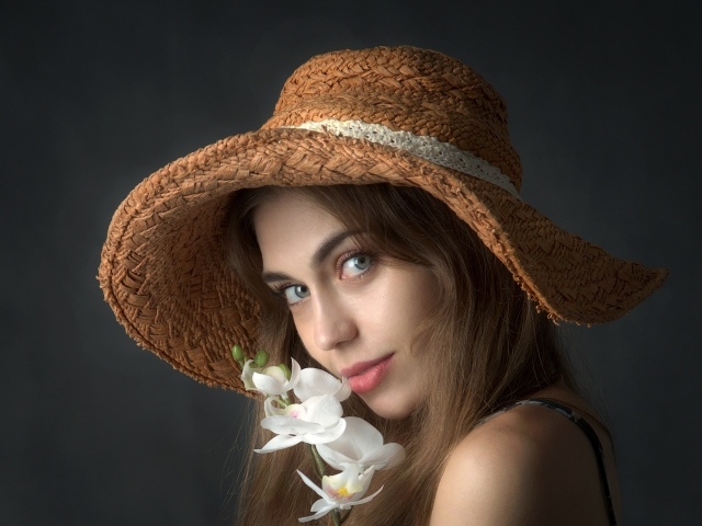 Девушка в шляпе с цветами орхидеи
