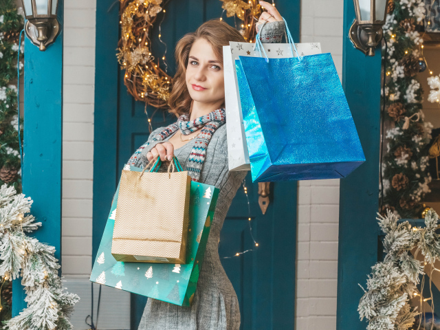 Девушка с пакетами стоит у двери