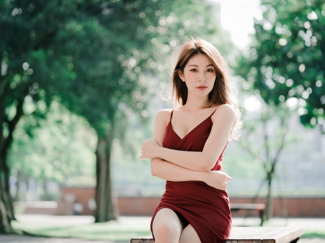 Серьезная девушка азиатка в красном платье