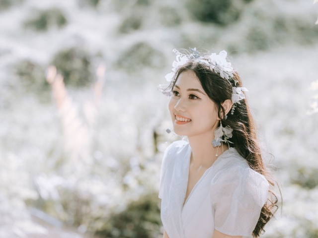 Улыбающаяся девушка азиатка в белом платье 