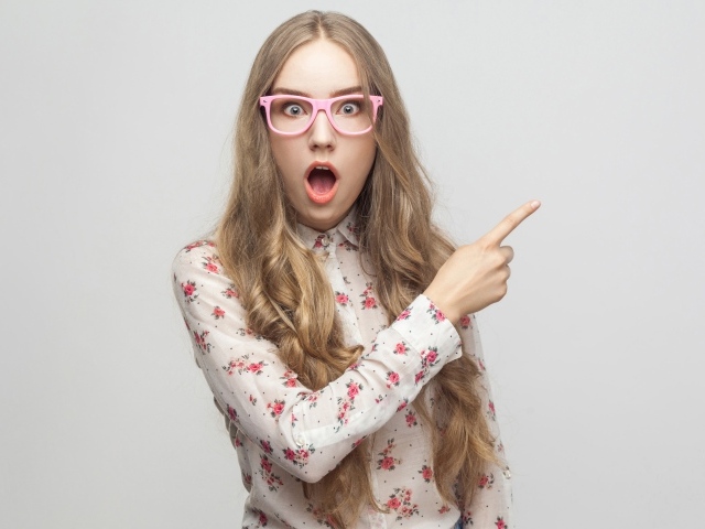 Удивленная девушка на сером фоне