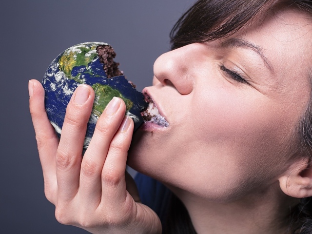 Девушка ест пирожное в виде планеты земля