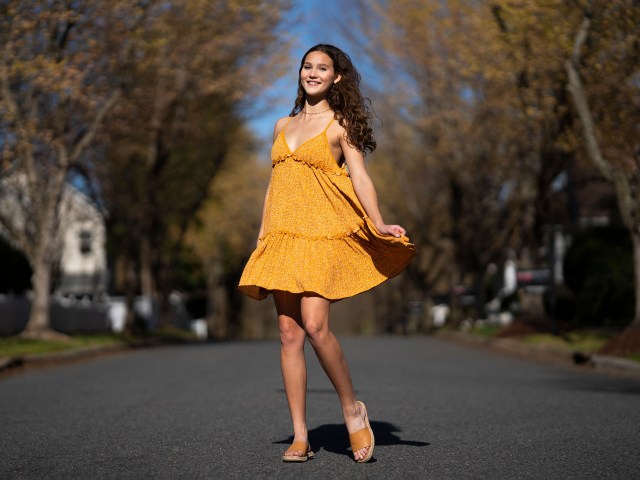 Молодая девушка в коротком платье на дороге  летом