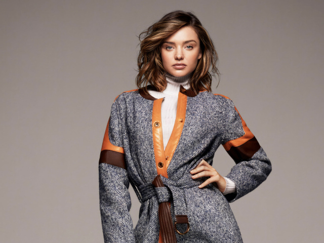 Стильная молодая модель Миранда Керр в пальто на сером фоне