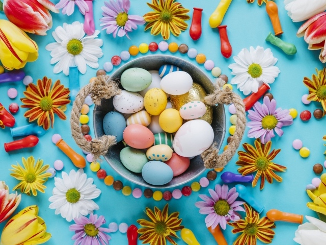 Разноцветные яйца с цветами на голубом фоне на Пасху