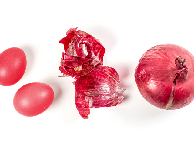 Окрашенные яйца с луком на белом фоне