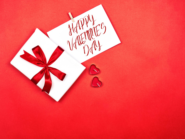 Открытка и подарок на красном фоне на День Святого Валентина