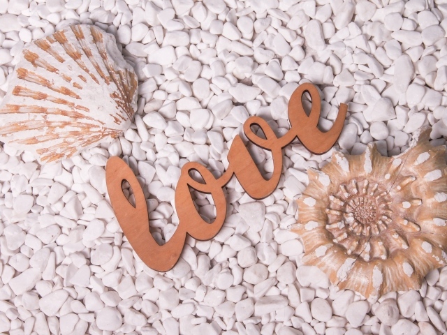 Ракушки и надпись любовь на белых камнях