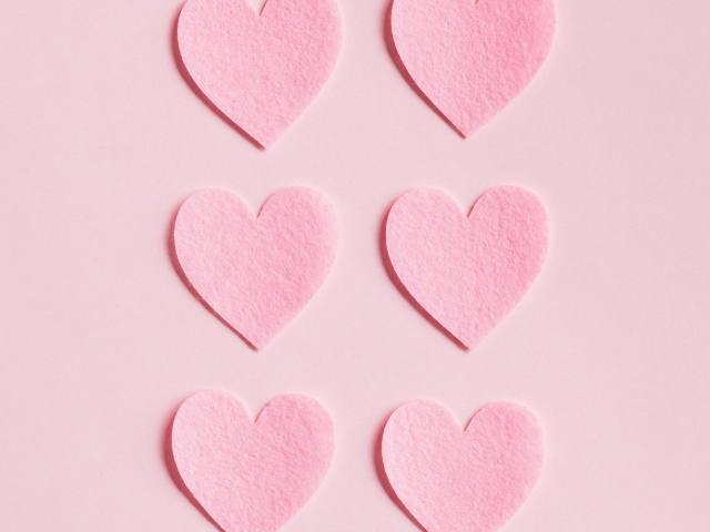 Маленькие бумажные сердечки на розовом фоне